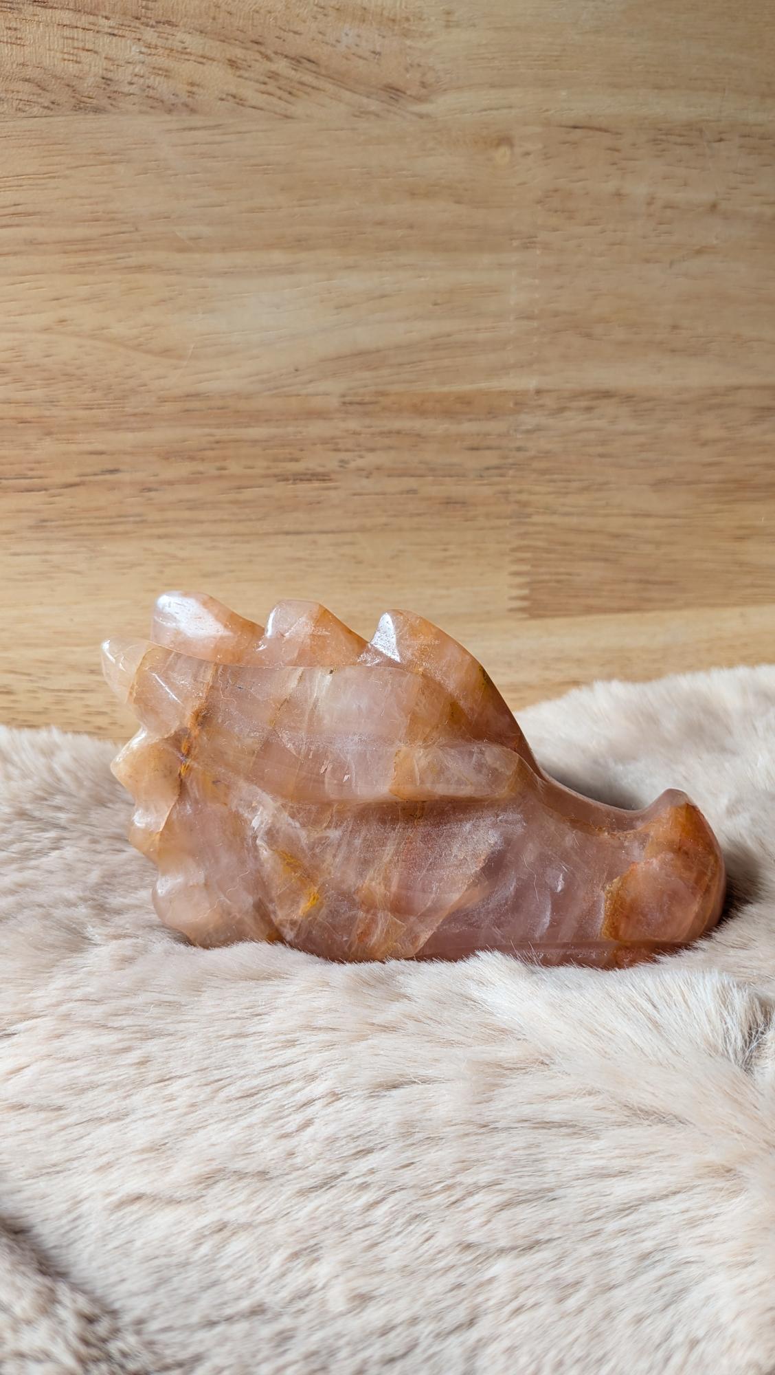 Gedetailleerde handgesneden draak carving van golden healer kwarts met warme gouden gloed.