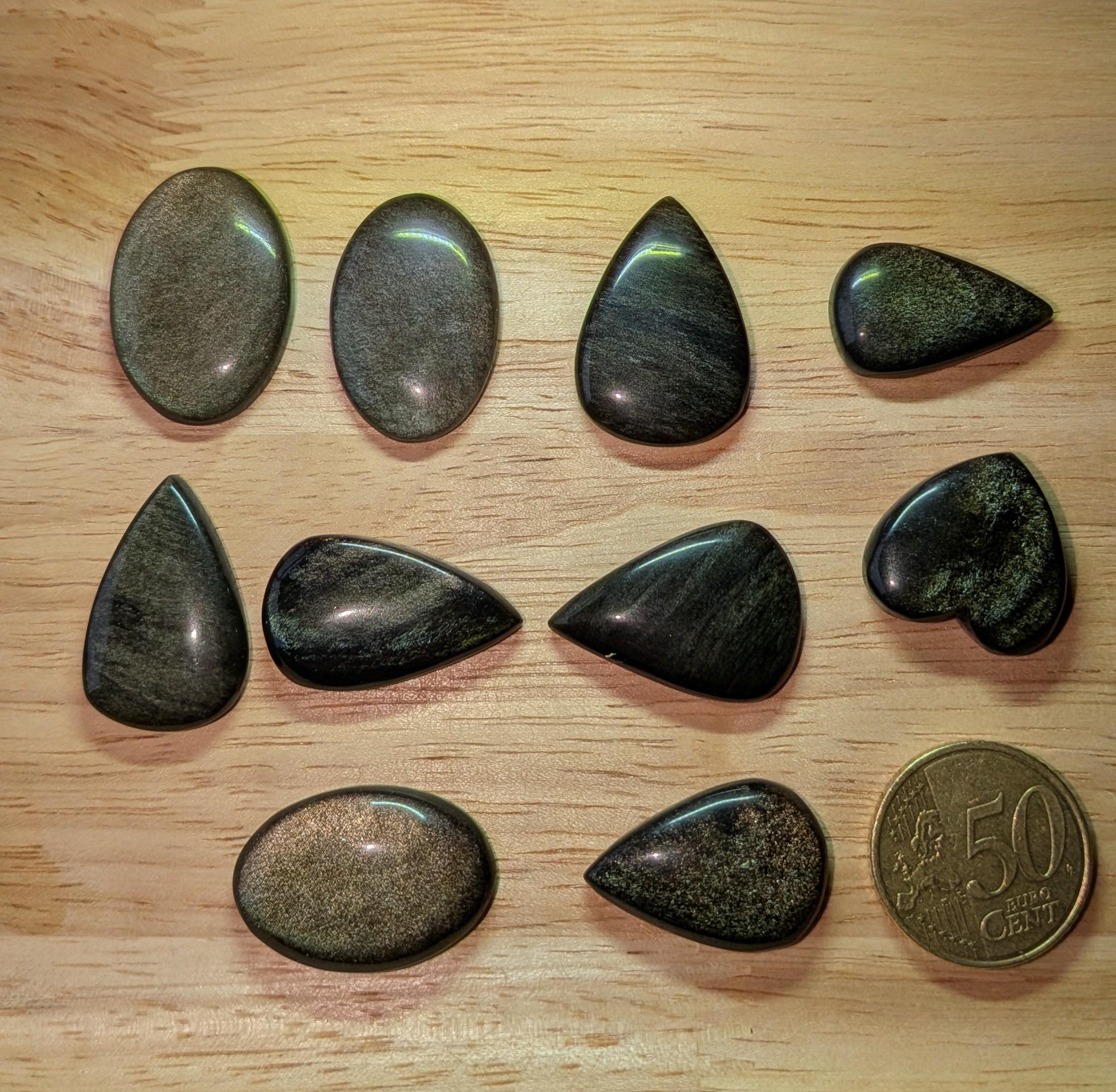 "Collectie Goud Obsidiaan cabochons met gouden gloed in hartvorm, druppel en ovaal voor custom wire wrapped hangers, naast een 50 cent munt."