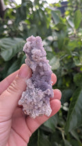 Een hand houdt een paars Grape agaat cluster van 52 gram vast, met een unieke bolvormige kristalstructuur