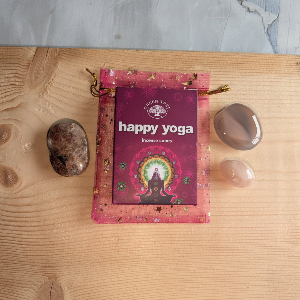 Geschenkset in een roze organza zakje met gouden sterren, bevattende een Bloemagaat trommelsteen, een Zonnesteen palmsteen, een Agaat palmsteen en een doosje Happy Yoga wierookkegels.