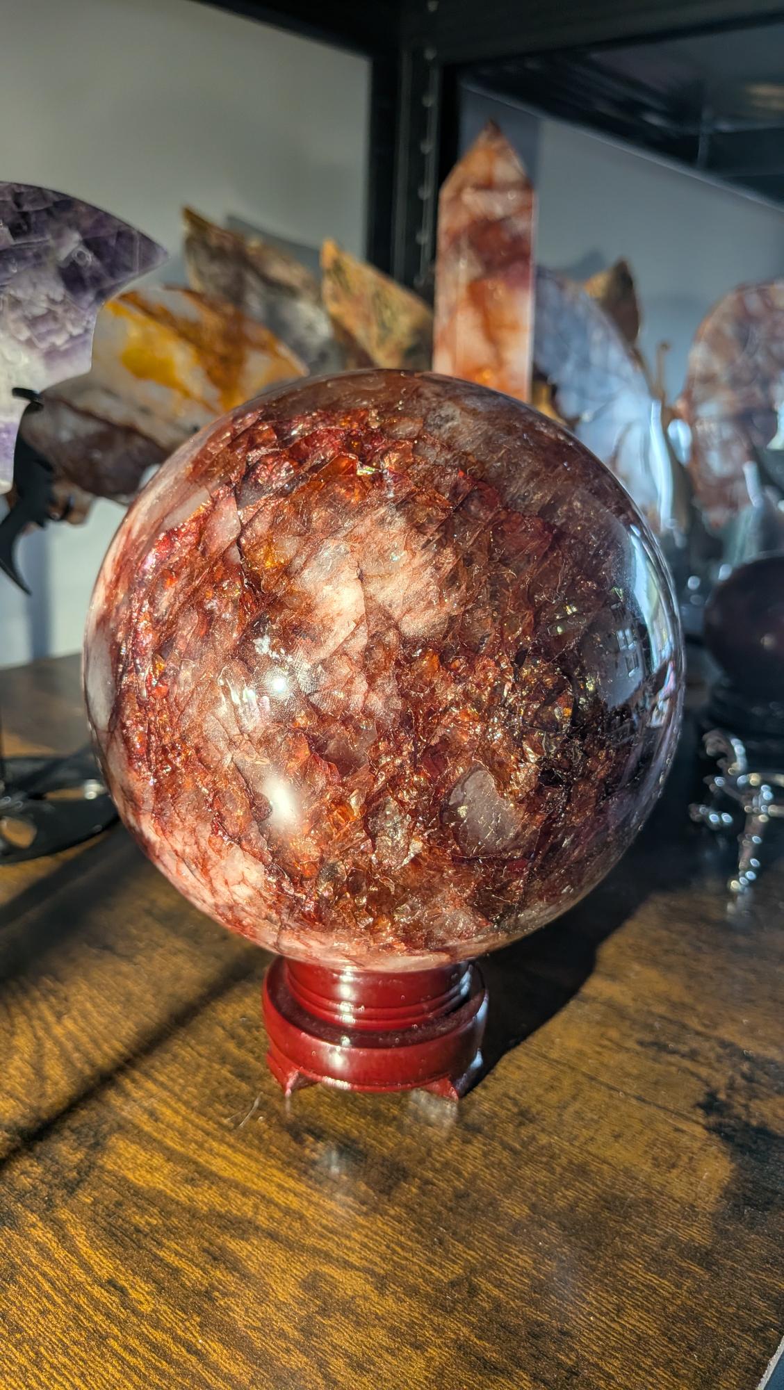 Exclusieve hematoïde kwarts bol van 3910 gram op rode standaard