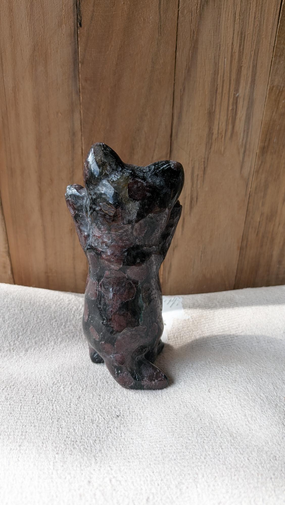 Gedetailleerde handgesneden kat carving van granaat met diepe roodbruine tinten.