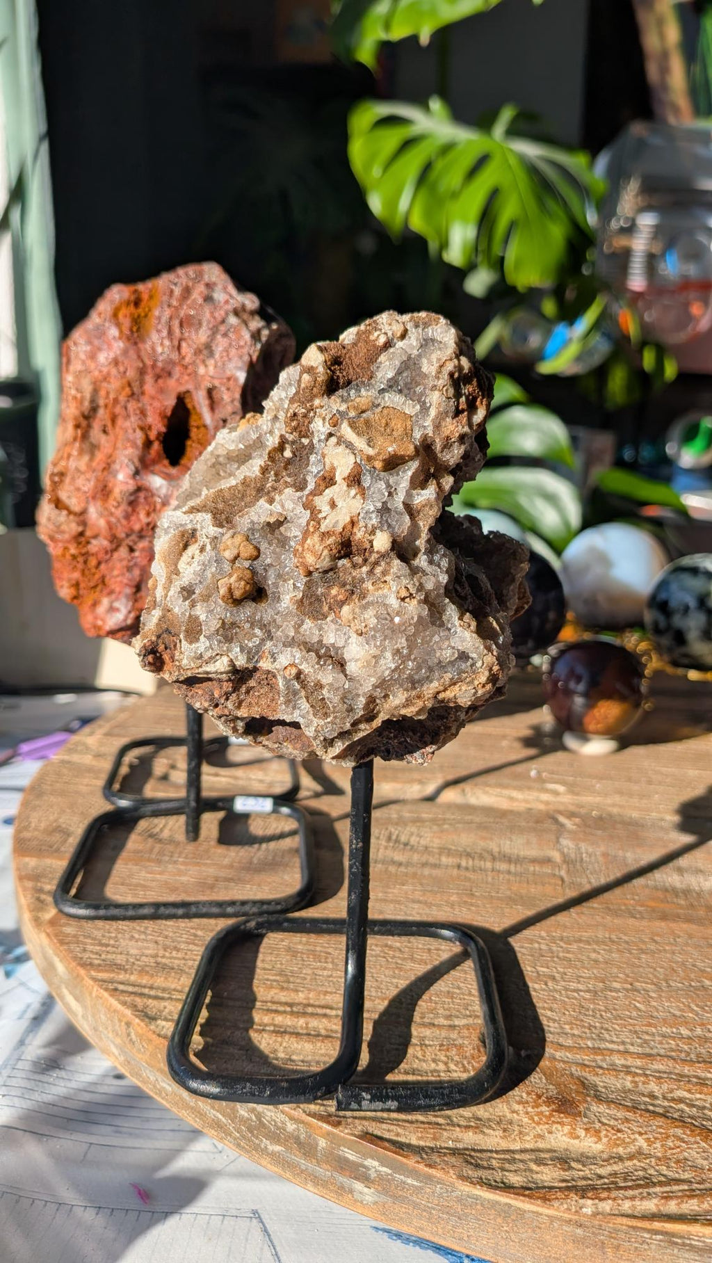 Voorzijde van een Braziliaanse kristalgeode op zwarte standaard met een prachtige open kristalstructuur.