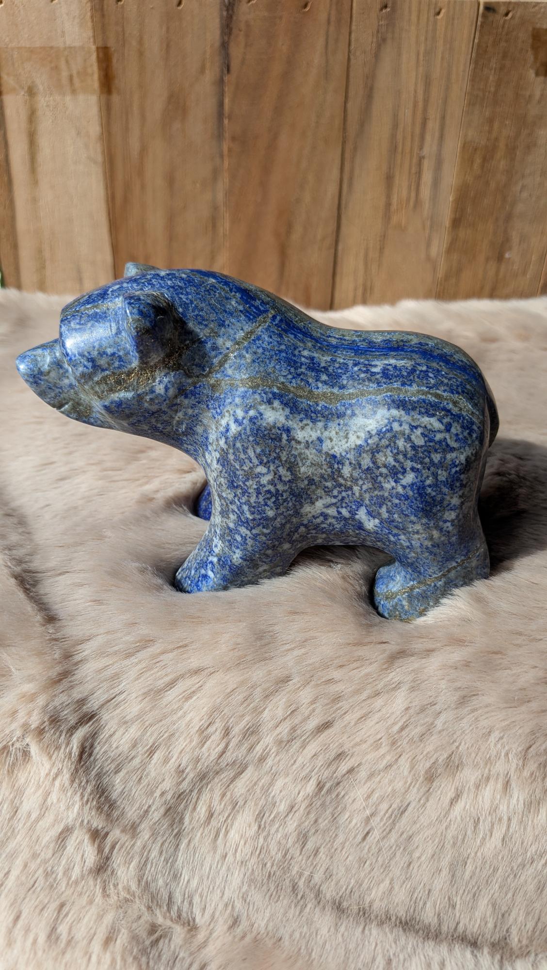 Gedetailleerde handgesneden beren carving van lapis lazuli met diepblauwe tinten.