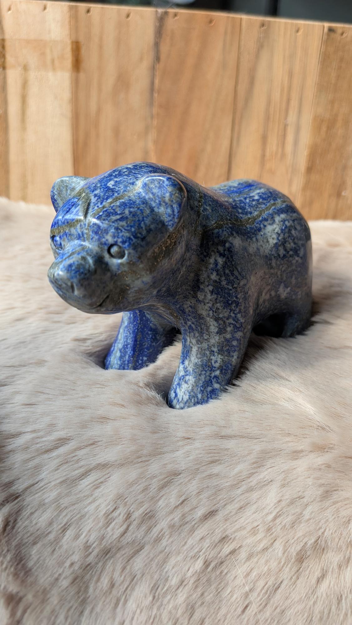 Vooraanzicht van een zware lapis lazuli beer van 554 gram op een houten ondergrond.