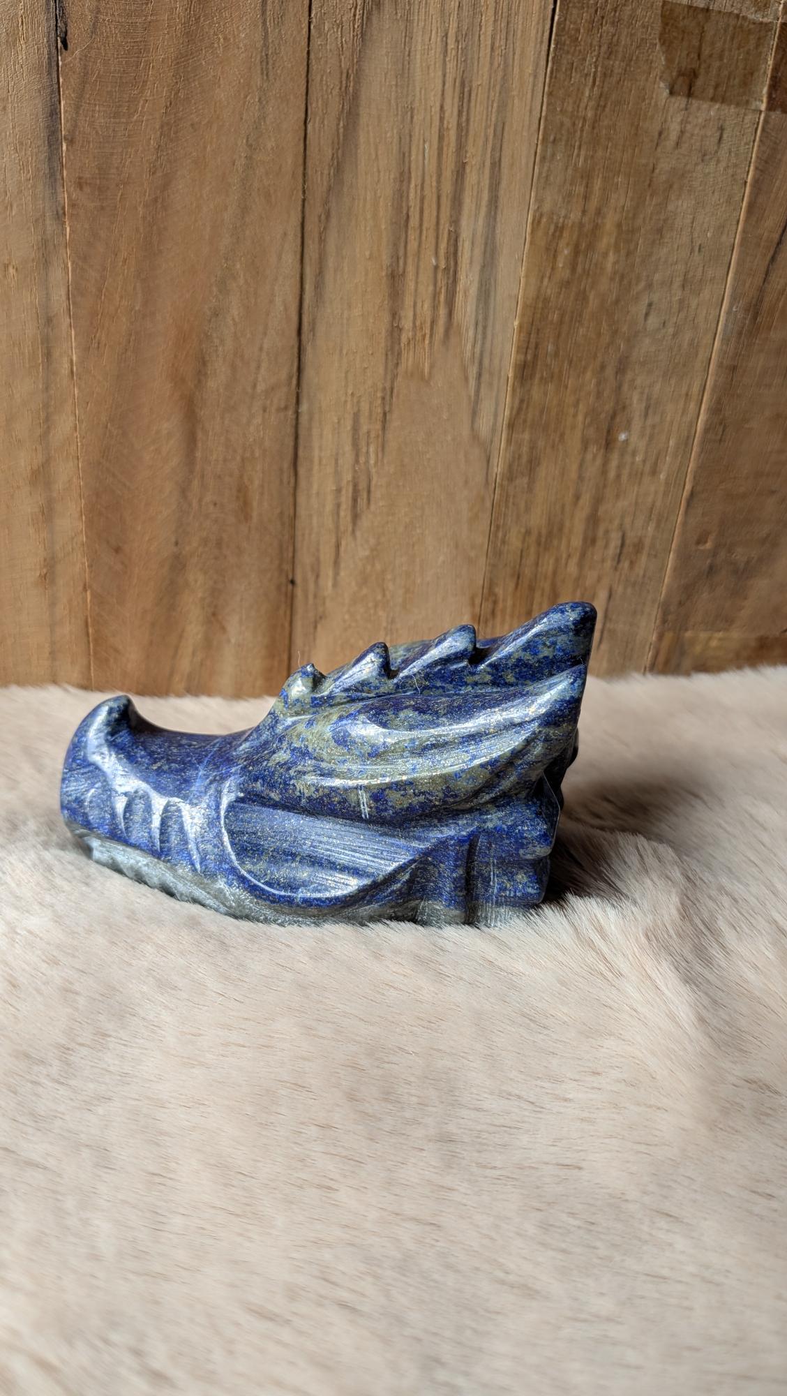 Gedetailleerde handgesneden draak carving van lapis lazuli met diepblauwe tinten.