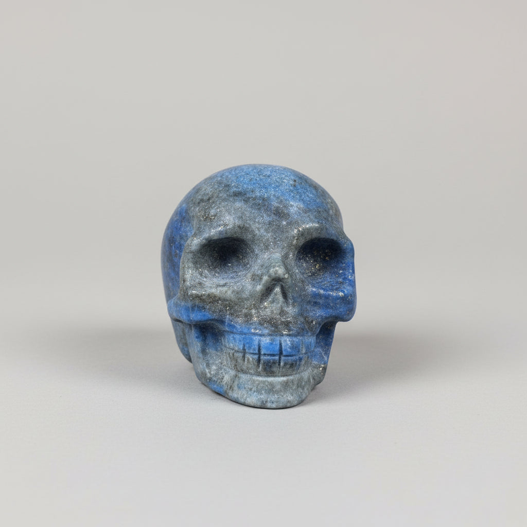 Handgesneden schedel van lapis lazuli met diepblauwe tinten op een houten achtergrond.