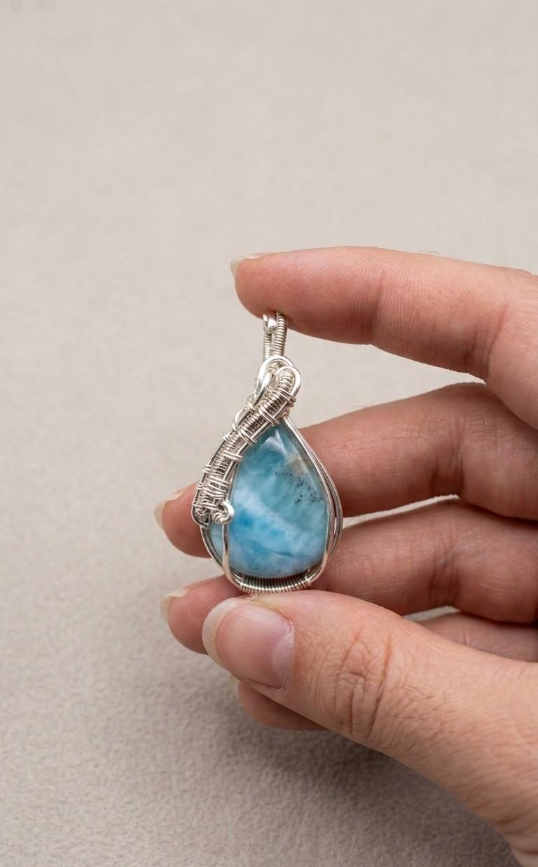 Handgemaakte druppelvormige Larimar hanger met gedetailleerd sterling zilveren wire-wrap vlechtwerk van Edeltwist, zoals getoond in 35977.png.