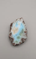Natuurlijk larimar plakje van 43 x 31 mm met organische vorm en blauw-groene tinten, gefotografeerd op een neutrale achtergrond.