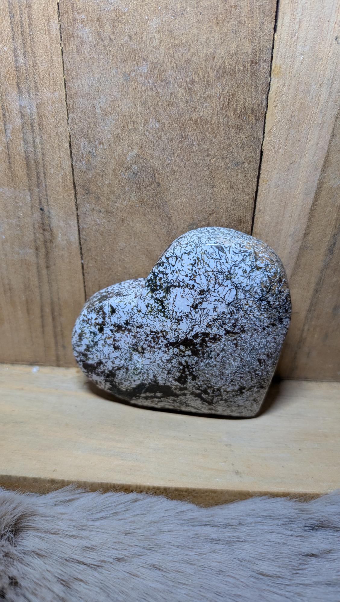 Middelmaat edelsteen hart van marcasiet in agaat met fijne donkere metallic patronen op een houten achtergrond