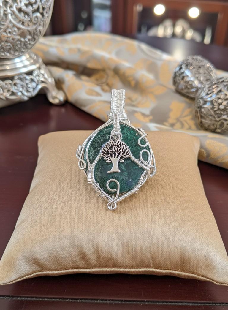 Handgemaakte groene Mosagaat hanger in verzilverd draad op een marmeren achtergrond - Edeltwist natuursteen sieraden.