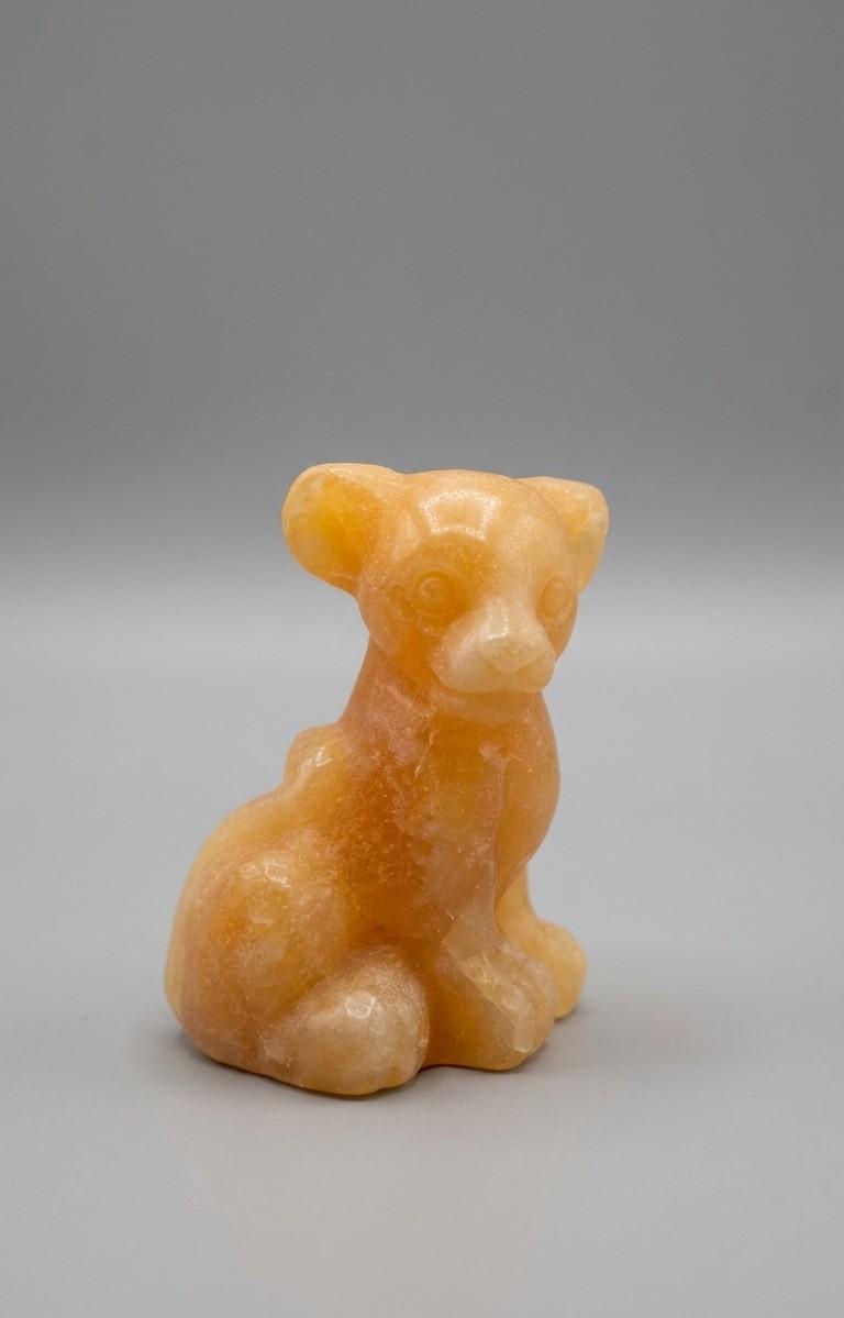 Gedetailleerd edelsteen figuur van de leeuwenwelp Nala, geslepen uit warme Gele Calciet met een zachte glans, zittende houding.