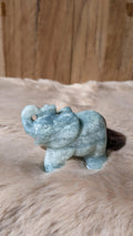 Gedetailleerde handgesneden olifant carving van Caribisch calciet met zachte blauw-groene tinten.