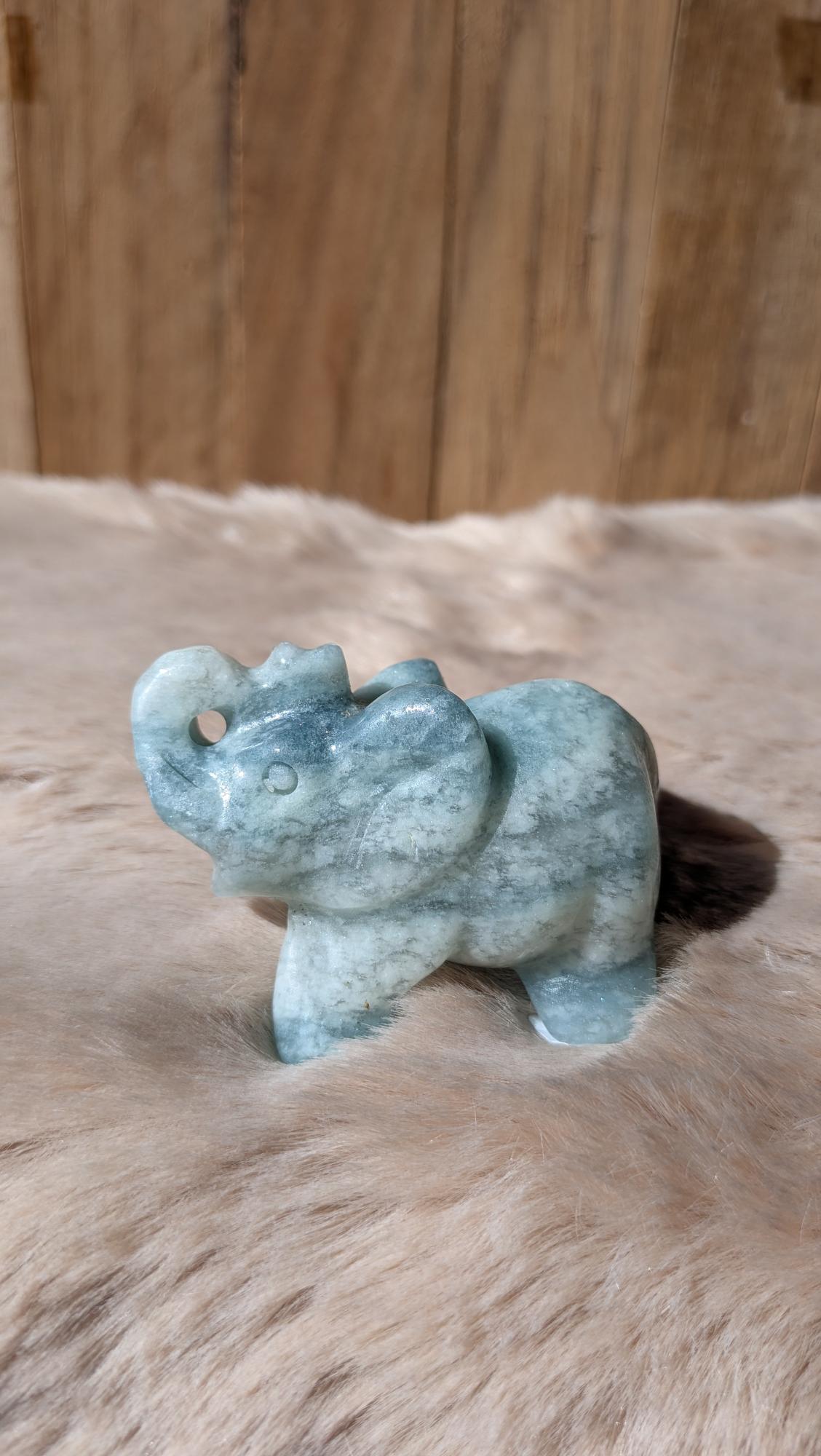Gedetailleerde handgesneden olifant carving van Caribisch calciet met zachte blauw-groene tinten.
