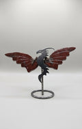 Handgeslepen kleine drakenvleugels van dieprode Jaspis op een zilverkleurige metalen drakenstandaard, 9 cm hoog, tegen een neutrale achtergrond.