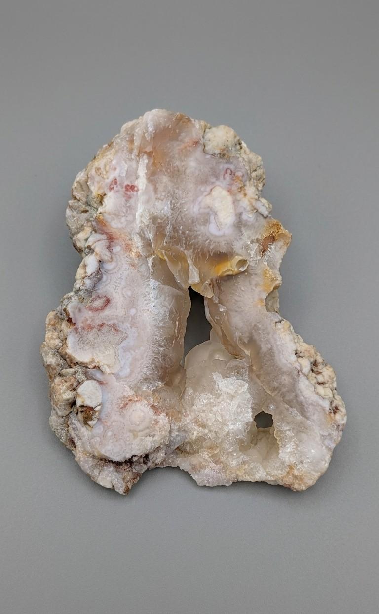 Detailopname van de suikerachtige kristaltextuur en zachte pastelkleuren van een roze amethist plak van 130 gram.