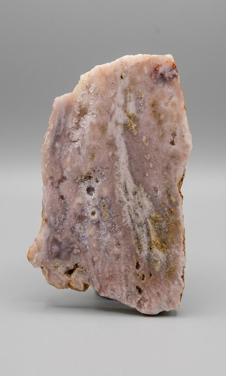 Detailopname van de suikerachtige kristaltextuur en zachte pastelkleuren van een roze amethist plak van 130 gram.