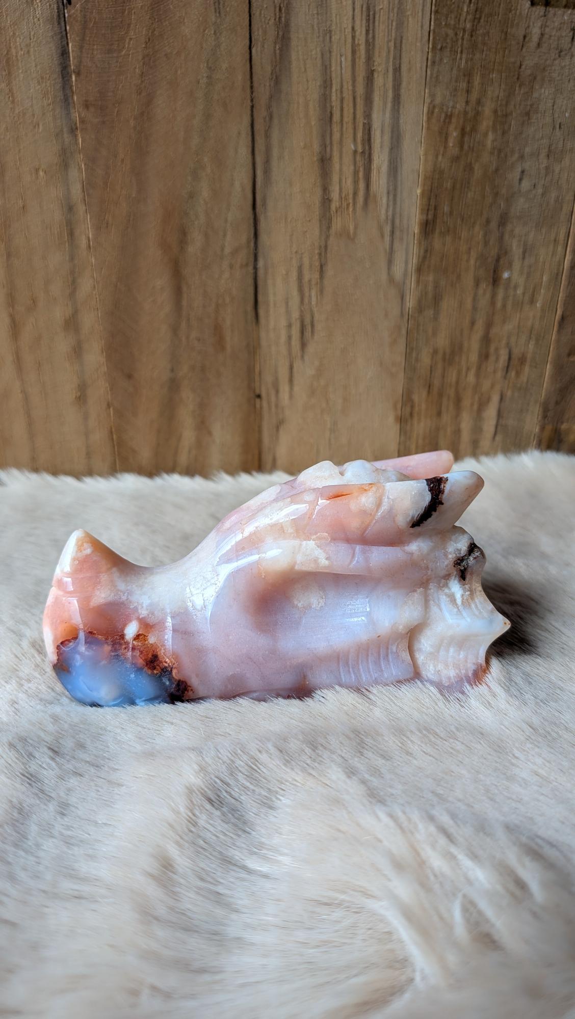 Gedetailleerde handgesneden draak carving van roze bloemagaat met zachte bloesempatronen.