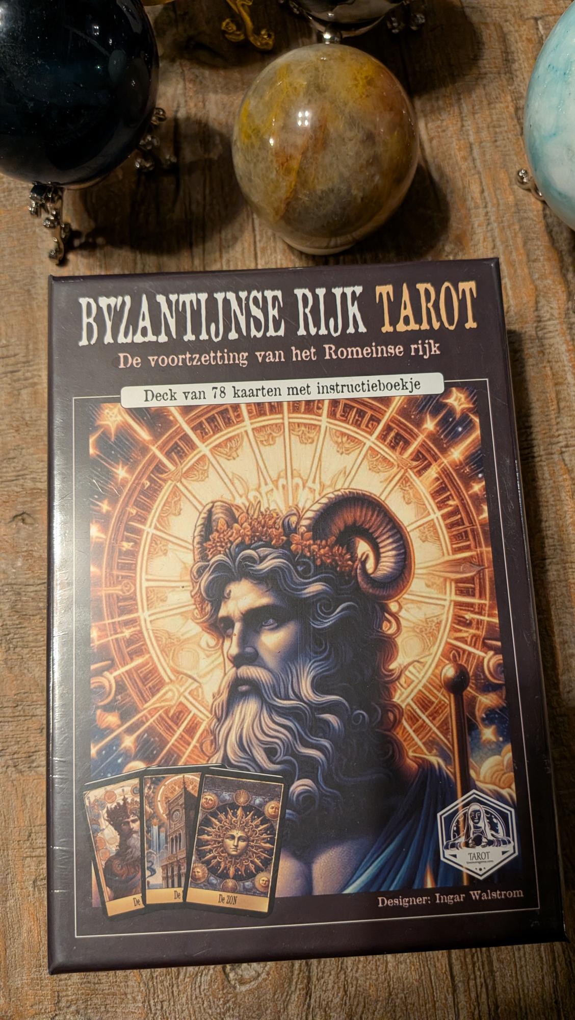 Donkere verpakking van de Byzantijnse Rijk Tarot door Ingar Walstrom met een gekroonde figuur met ramshoorns en voorbeelden van kaarten zoals De Zon.