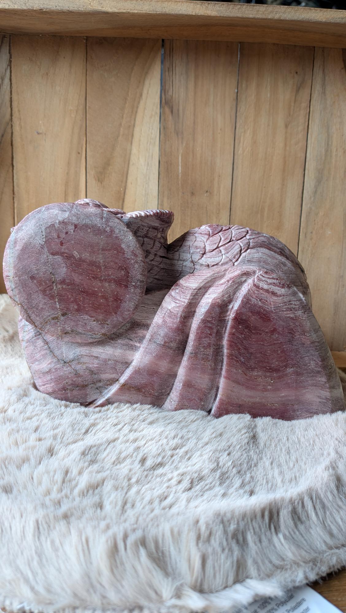 Zijaanzicht van een zware jaspis uilencarving met natuurlijke banden en texturen.