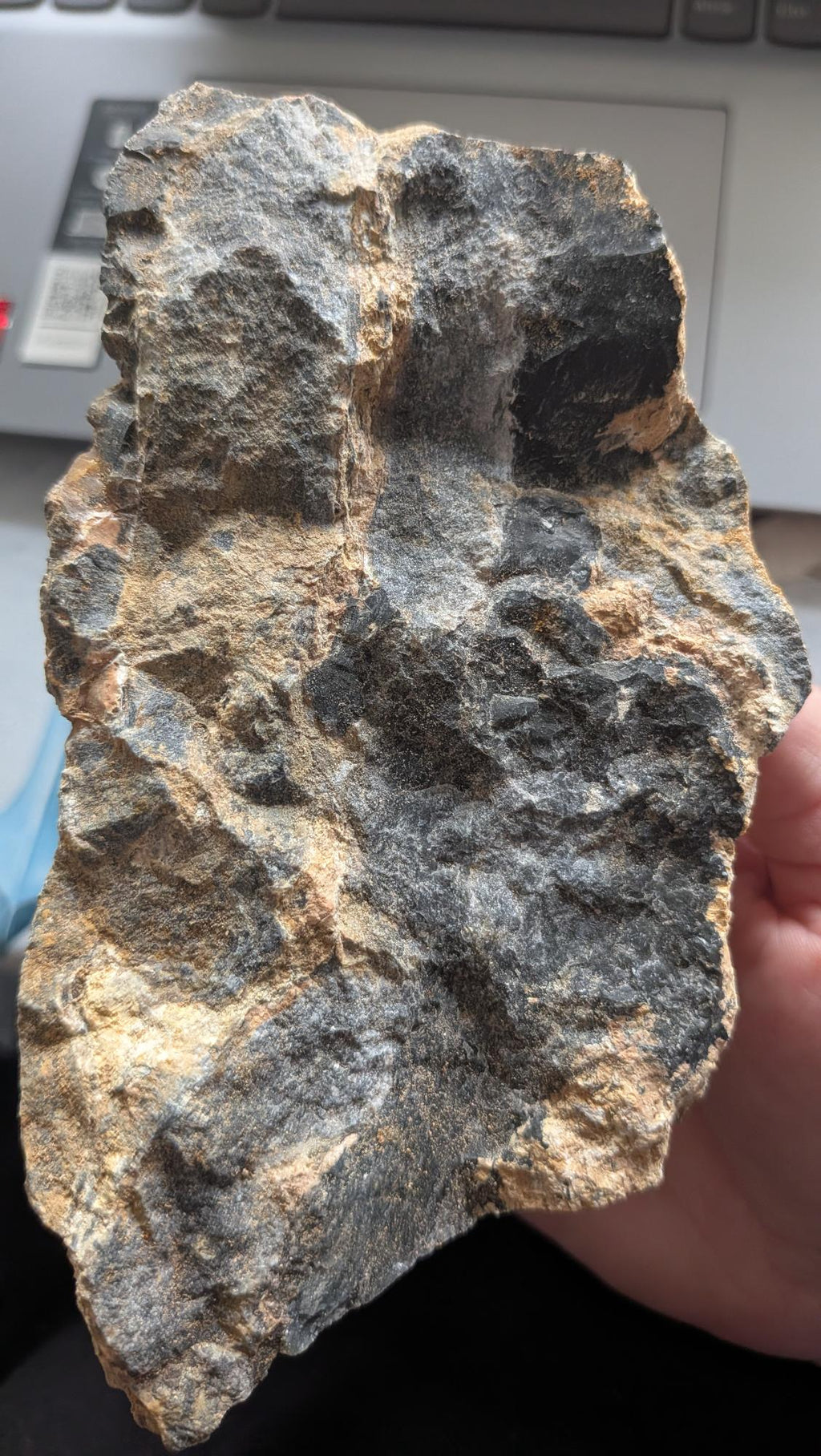 Een massief stuk Vuursteen in matrix van 914 gram met een zwarte, glanzende kern en een ruwe, bruine buitenkant, gefotografeerd op een digitale weegschaal.