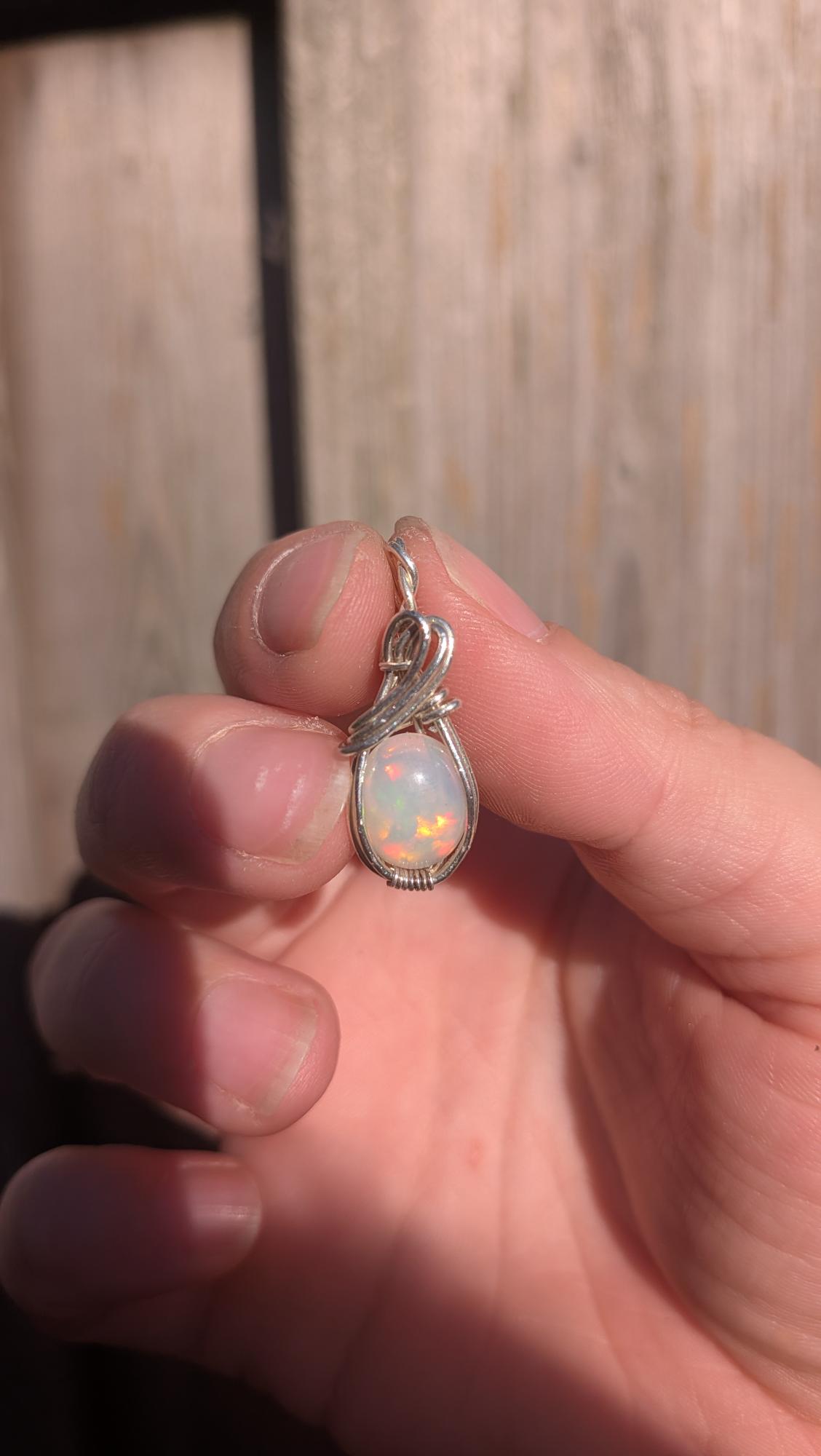 Massieve handgemaakte hanger met witte Welo opaal en dik sterling zilveren vlechtwerk in het zonlicht, zoals getoond op shared image (30).jpg.