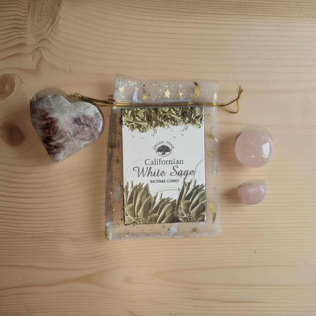 Geschenkset in een organza zakje met maantjes en sterren, bevattende een Zonnesteen hart, twee stukken Rozenkwarts en een doosje Californian White Sage wierookkegels.