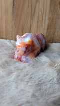 Gedetailleerde handgesneden wolf carving van bloemagaat met warme carneool accenten.