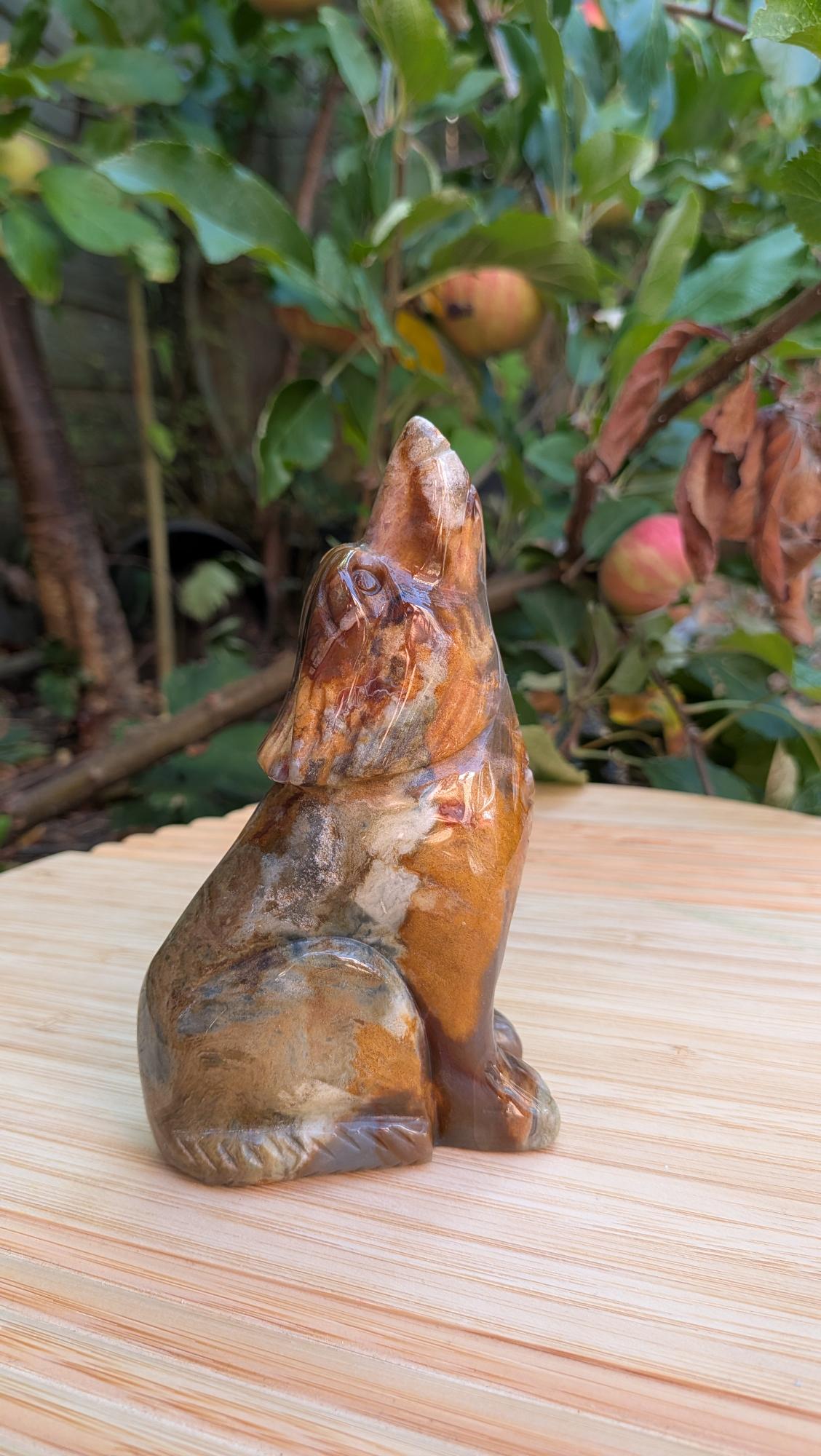 Zijaanzicht van de handgesneden wolf carving van oceaanjaspis met unieke patronen