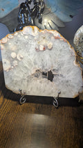 Grote edelsteen slab van bloemagaat van 477 gram met heldere kwartskristallen en een open druzy geode op een houder
