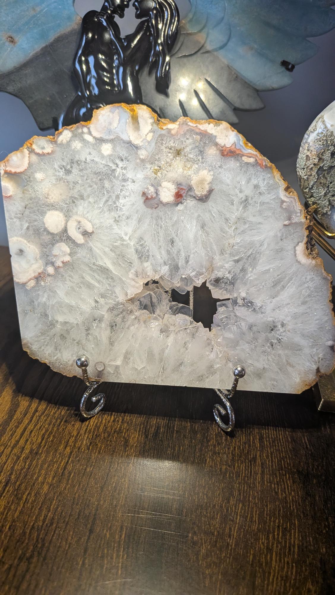 Grote edelsteen slab van bloemagaat van 477 gram met heldere kwartskristallen en een open druzy geode op een houder