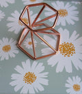Moderne roségouden geometrische bollenhouder van metaal. Omkeerbaar ontwerp met openingen van 4 cm en 5,5 cm voor verschillende maten edelsteen bollen. Prijs 4,95 euro.
