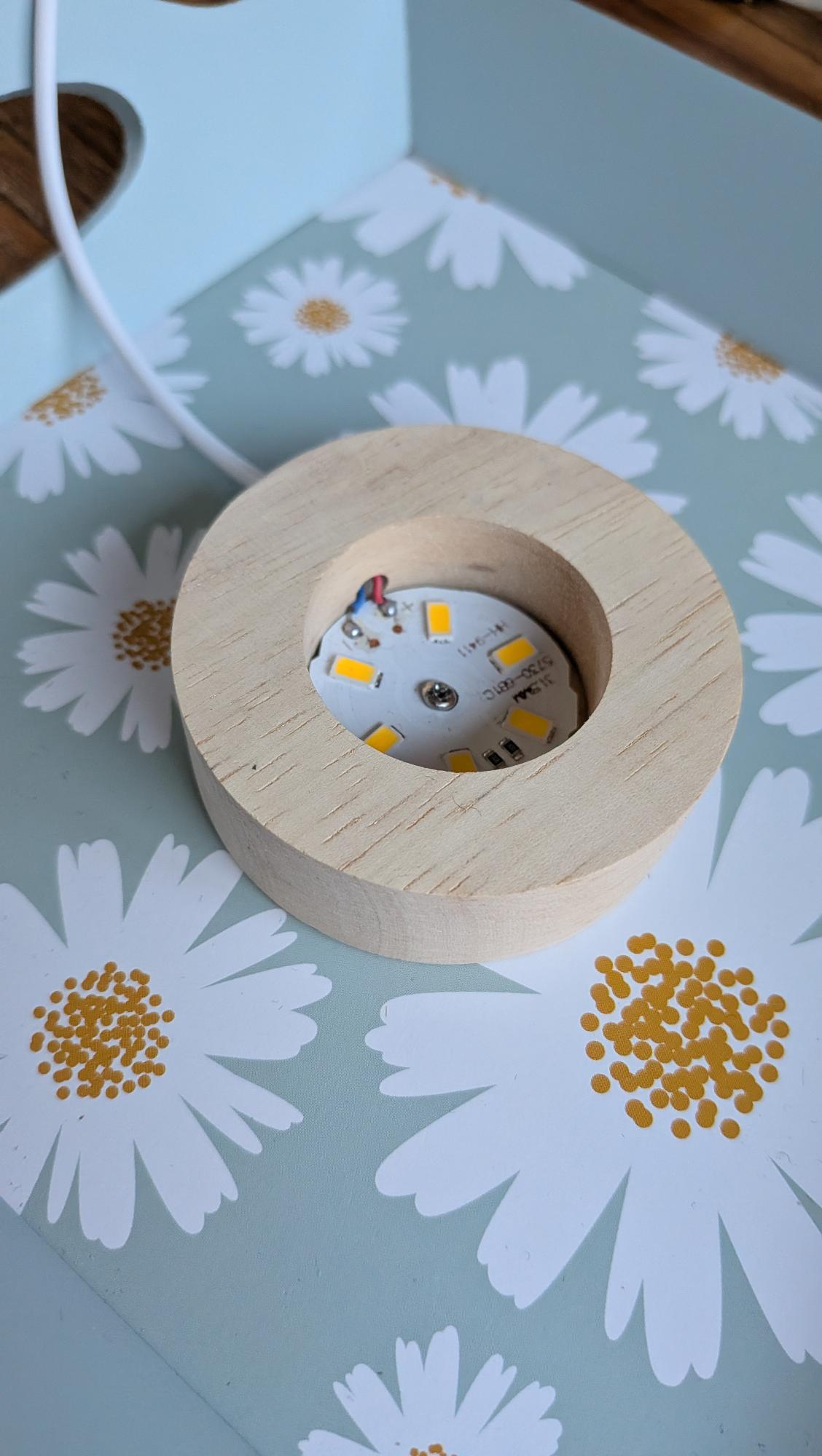 Brede houten LED-basis voor grote edelsteen bollen tot 10 cm, voorzien van USB-kabel en warm wit licht. Ideaal voor het verlichten van kristallen. Prijs 12,50 euro.