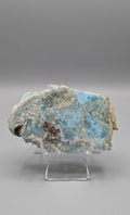 Gepolijste wit-blauwe Larimar plak met oceanisch patroon op een transparante acrylaat standaard van Edeltwist.