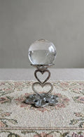 Zilverkleurige metalen bollenhouder met twee harten en een bloemvormige voet, bovenplaat 3 cm, geschikt voor edelsteen bollen.