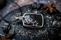 Handgemaakte zwarte Nuummiet hanger met goudkleurige flitsen en verzilverd wire wrap werk, inclusief gratis koordje en luxe doosje.
