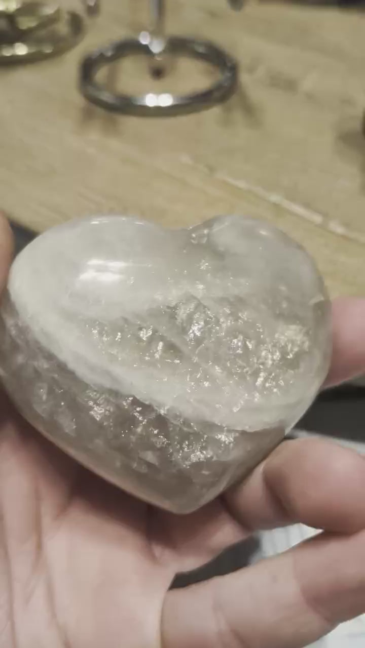 "Close-up van de melkachtige gelaagdheid en de zachte glans in een gepolijst Maansteen hart."