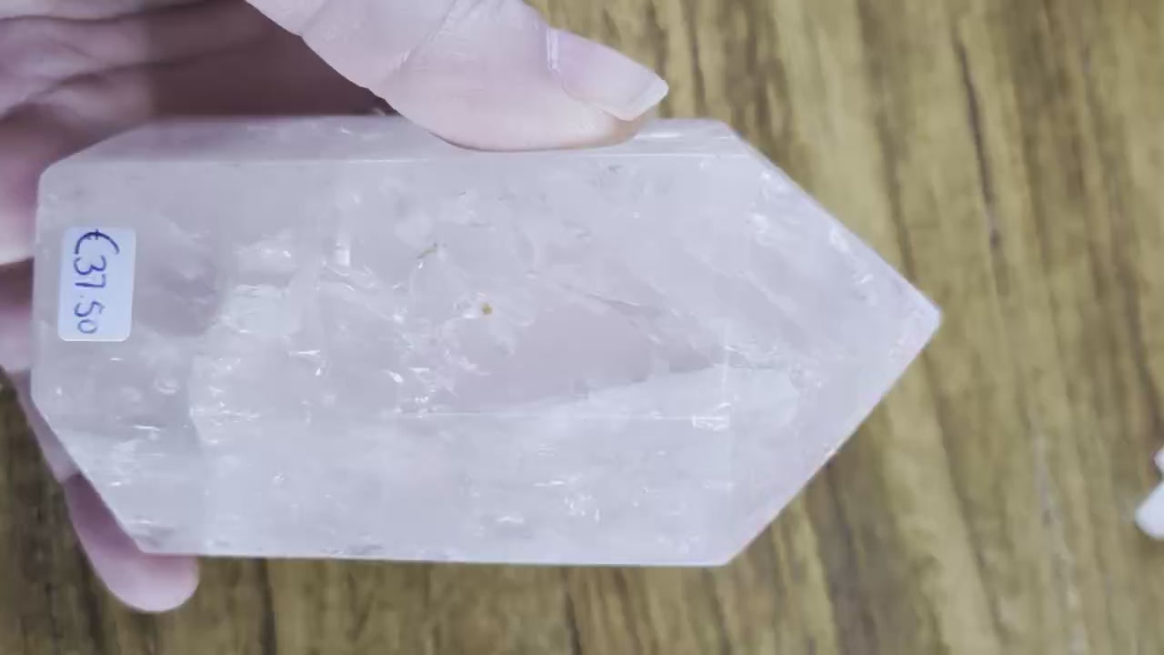 Grote, robuuste Rozenkwarts kristal toren van 10,5 cm hoog met een gewicht van 524 gram op een houten ondergrond.