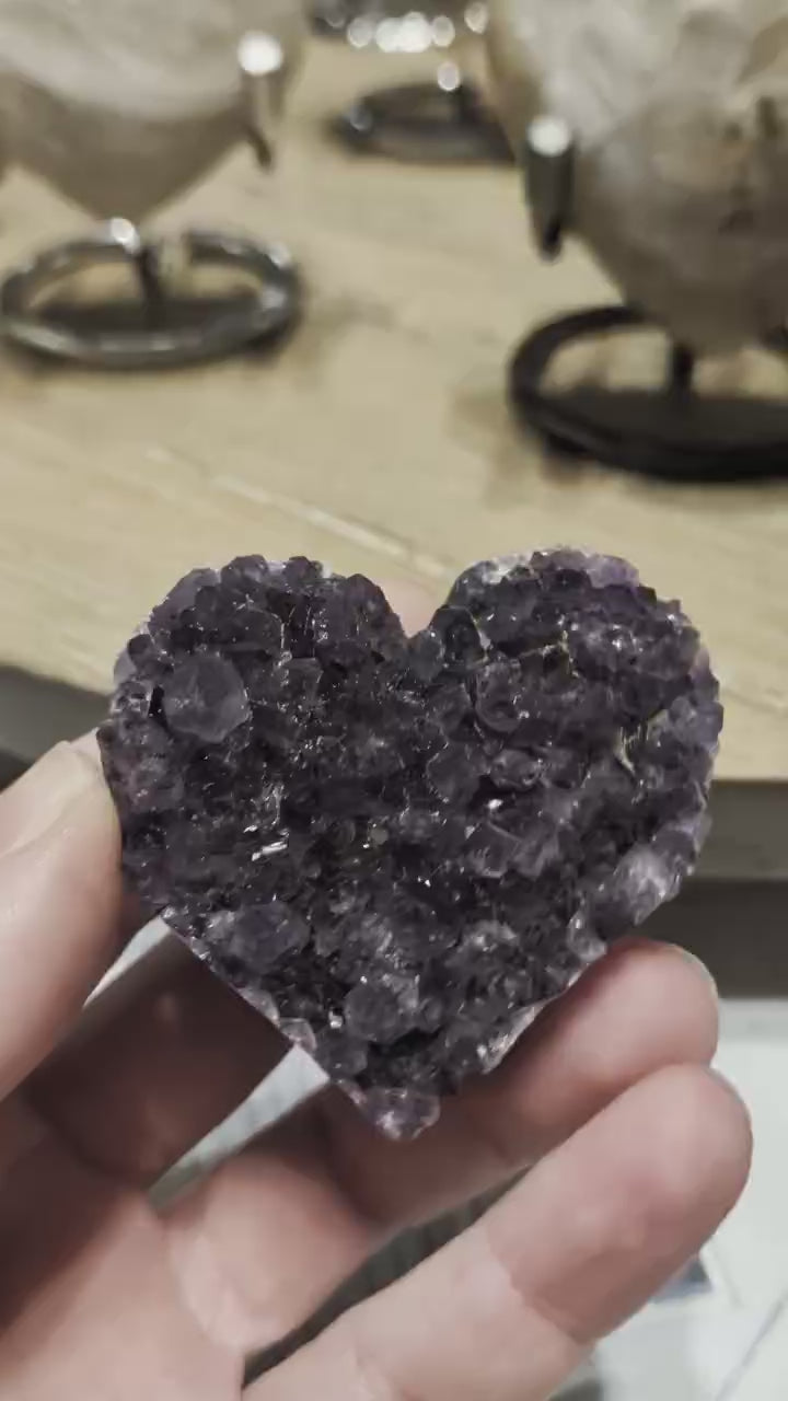 "Zijaanzicht van een Amethist hart waarin de overgang tussen de ruwe geode-rand en de gepolijste achterkant zichtbaar is."