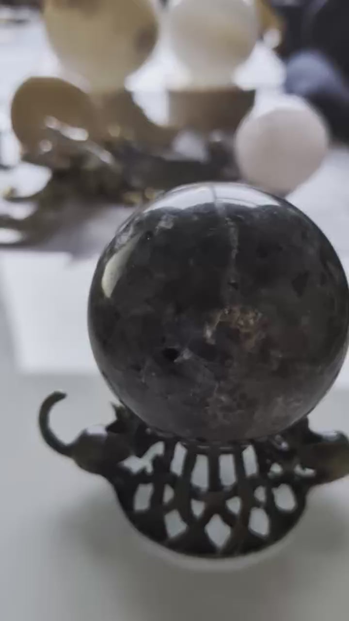 Demonstratie van een Yooperliet bol die fel oranje oplicht (lava-effect) wanneer er met een UV-zaklamp op wordt geschenen.