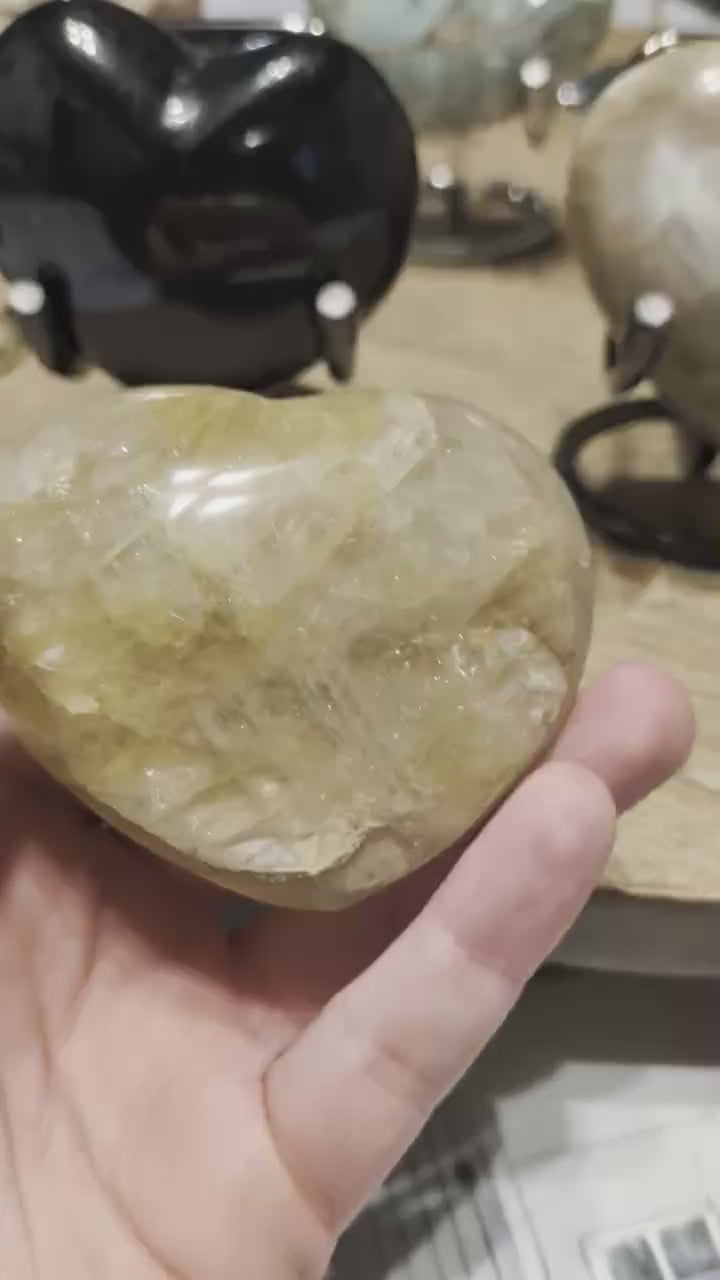 "In deze video draait het Golden Healer hart langzaam in het licht, waardoor de diepte van de kristallen en de zonnige kleur prachtig zichtbaar worden. Je ziet hoe de glans over de gepolijste vlakken beweegt."