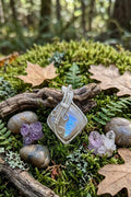 Handgemaakte Regenboog Maansteen hanger met een blauwe glans, een grote verzilverde spiraal en wire wrap vlechtwerk, inclusief gratis koordje.