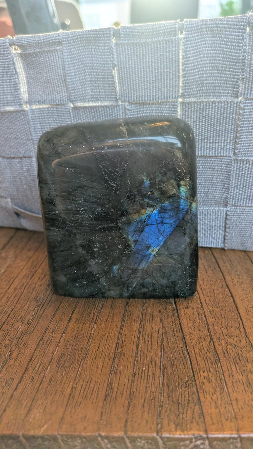 "Handgepolijste vrije vorm van Labradoriet met een intense blauwe en gouden glans, 9 cm hoog en 473 gram, getoond in een hand om de schittering te laten zien."