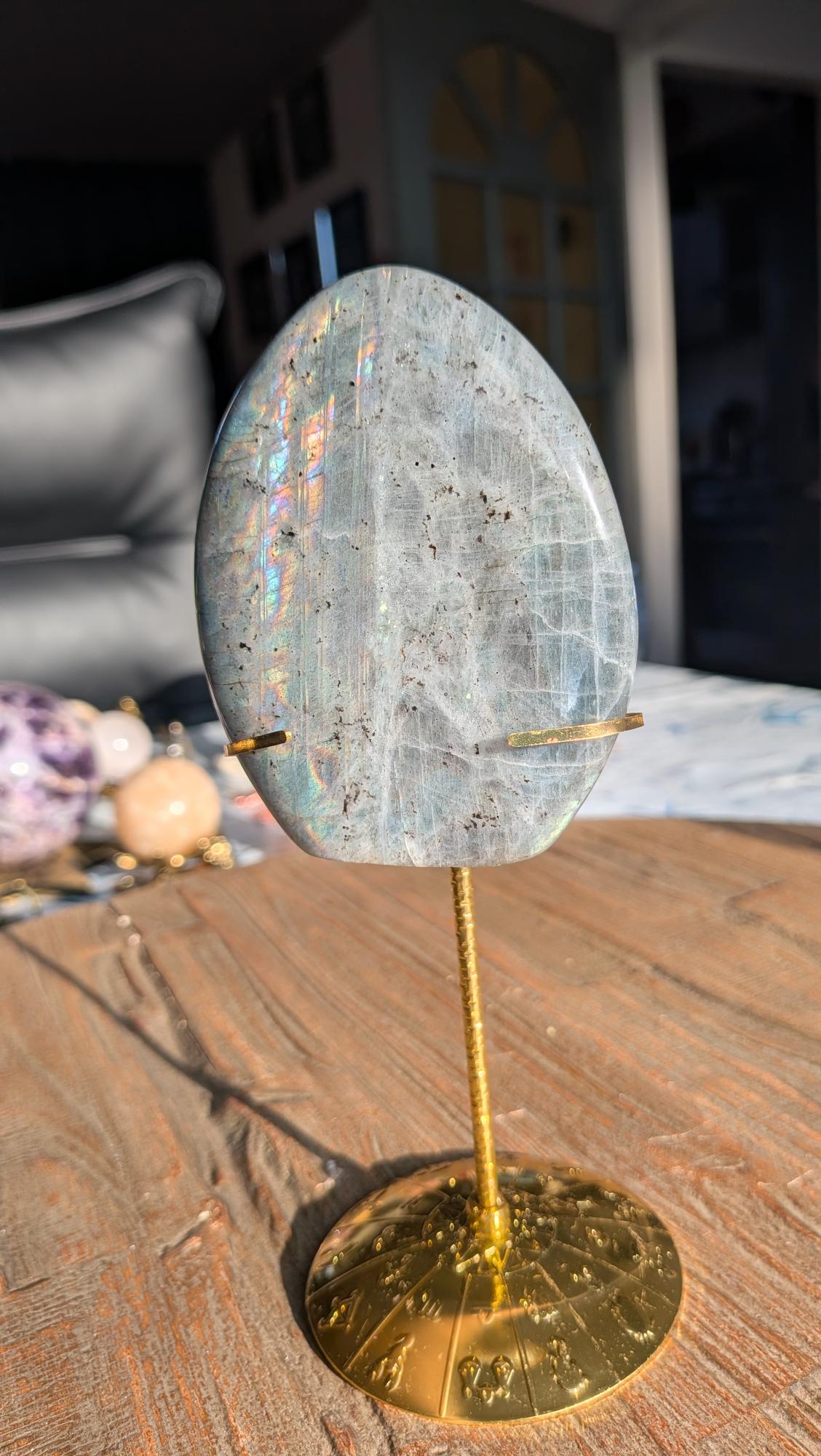 Grote AAA+ Labradoriet edelsteen 237 gram met intense verticale regenboog flash op een luxe goudkleurige standaard met gegraveerde voet