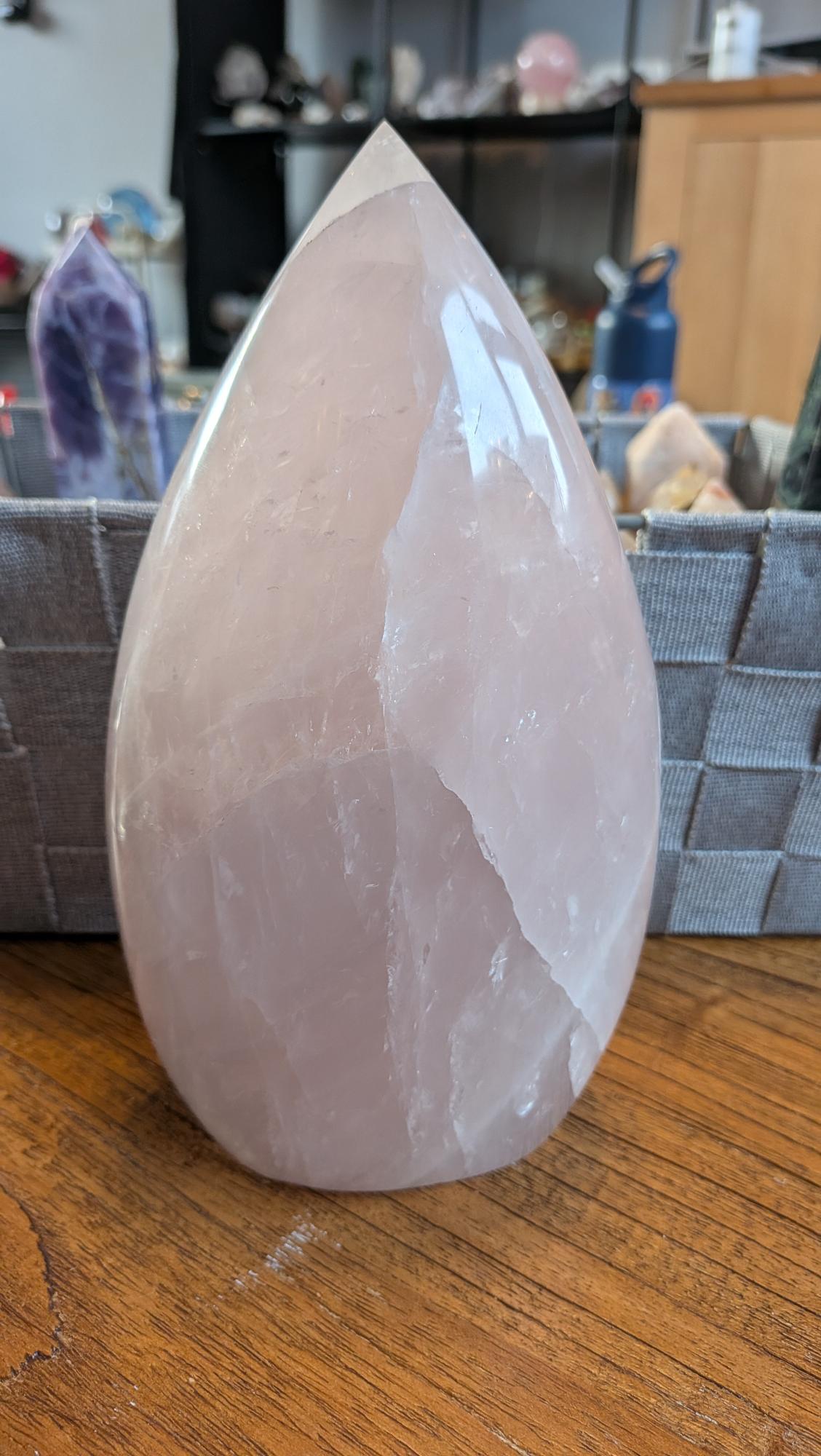 "Indrukwekkende XL Rozenkwarts vrije vorm van 20 cm hoog en 1936 gram, met zachte roze tinten en een gepolijste glans op een houten ondergrond."