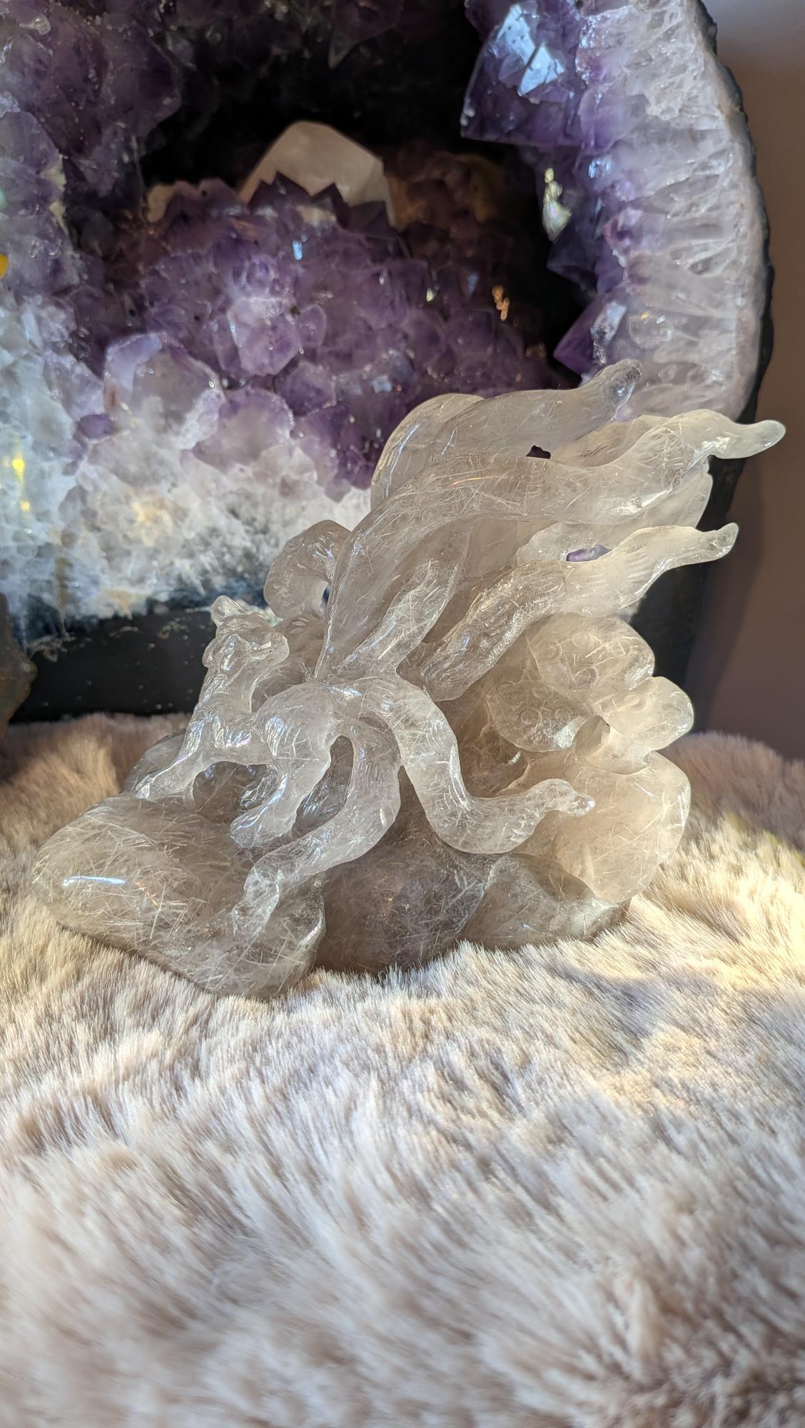 Voor-zijaanzicht van handgecarvede rutilerend rookkwarts ninetails vos op harige ondergrond.