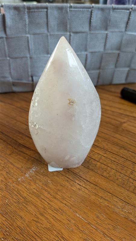 Gepolijste punt van Bloemagaat met zachte roze en witte patronen op een houten ondergrond, 10 cm hoog en 245 gram.