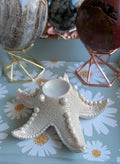 Luxe witte zeester bollenhouder met parelmoerglans, 10 cm breed met een 3,5 cm binnenring. Decoratief oceanisch display voor edelsteen bollen, prijs 12,50 euro.